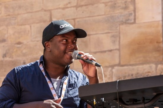 Photo en gros plan de Hervé Fontaine, micro à la main et casquette sur la tête, lors du festival Bar'EnVoix 2023