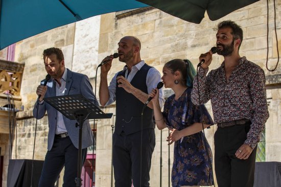 Les 4 membres du groupe Climax, micro à la main, en train de chanter.