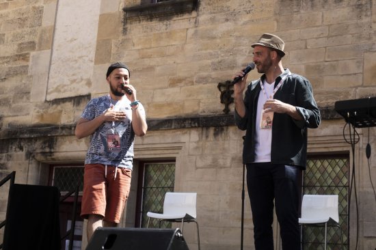 Improvisation Festival Bar'Envoix 2023. Julien et Rémy, micro à la main chantent sur scène.