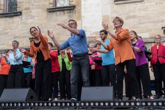 Photo de la chorale Octavia lors du festival Bar'EnVoix 2023. 7 chanteurs tapent des mains sur l'avant scène.