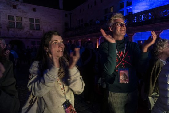 Emmanuel et Nolwenn, sourire au lèvres applaudissent dans la cour du collège Gilles de Trèves baigné dans une ambiance bleue