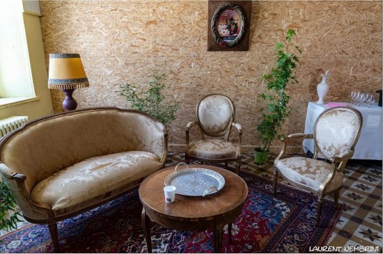 Bar'EnVoix 2023 - Photo des coulisses - La loge des artistes avec un canapé et deux fauteils stylé sur un tapis. La pièce est décrée de cadres et plantes vertes?