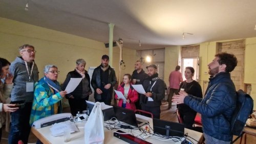 Moment de détente, des membres du groupe Opus Jam avec quelques membres de l'association EnVoix répètent un chant dans le bureau du festival lors de la mise en place.