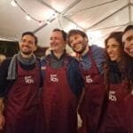 Les cinq chanteurs du groupe italien Mezzotono posent avec un tablier de barman bordeaux avec le logo Bar'EnVoix.