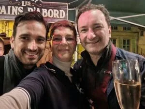Fabio, avec une coupe de champagne à la main, et Andrea du groupe italien Mezzotono posent avec Céline pendant la soirée de l'After.