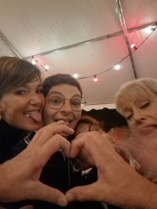 Les membres de l'association EnVoix posent pour un selfie en faisant un cœur avec les doigts et en tirant la langue avec un grand sourire.