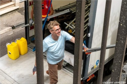 Emmanuel décharge du camion les pièces d'un barnum de 15 mètres... avec le sourire