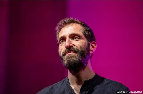 Gros plan sur Mathis, du groupe Ommm sur un fond éclairé de mauve.