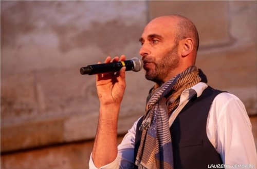 Gros plan sur Julien du groupe Opus Jam, micro en main en train de chanter.