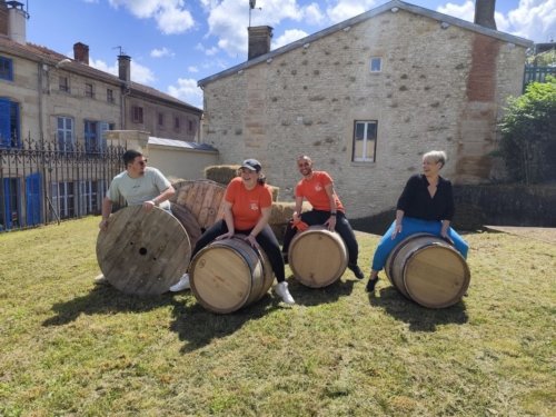 4 membres de l'association à califourchon sur des tonneaux et tourets s'amusent lors de l'installation de la guinguette. Il faut des moments de détente, c'est ça l'association...