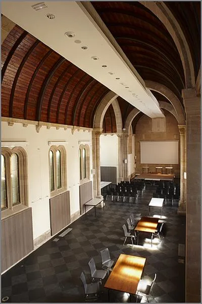 Intérieur de la chapelle du Lycée Raymond Poincaré avec tables et chaises et plafond voûté.