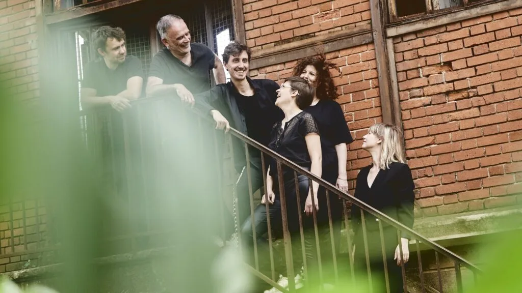 Photo du groupe Exeko sur un escalier devant une maison de brique