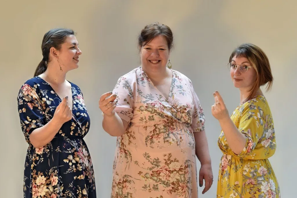 Photo de groupe du trio Les Chanteuses Anonymes en robe fleuries