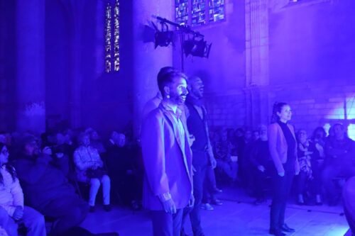 Dans une ambiance bleue, le groupe ClimaX chante en se dirigeant vers la nef