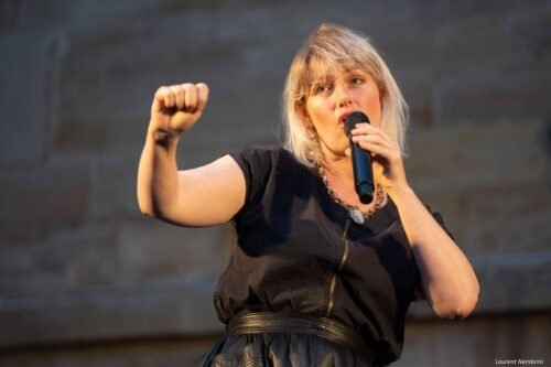 Photo de Célia du groupe Exeko, micro à la main en train de chanter