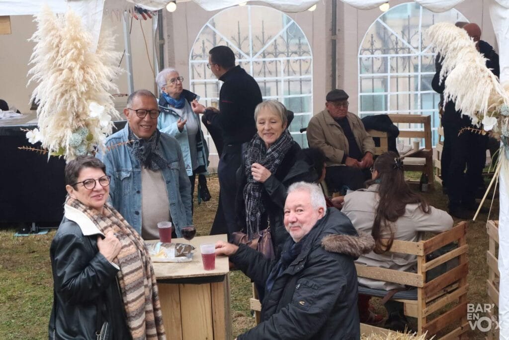 Les festivaliers devant leurs verres ou assis sur des bancs de palettes pendant la guinguette