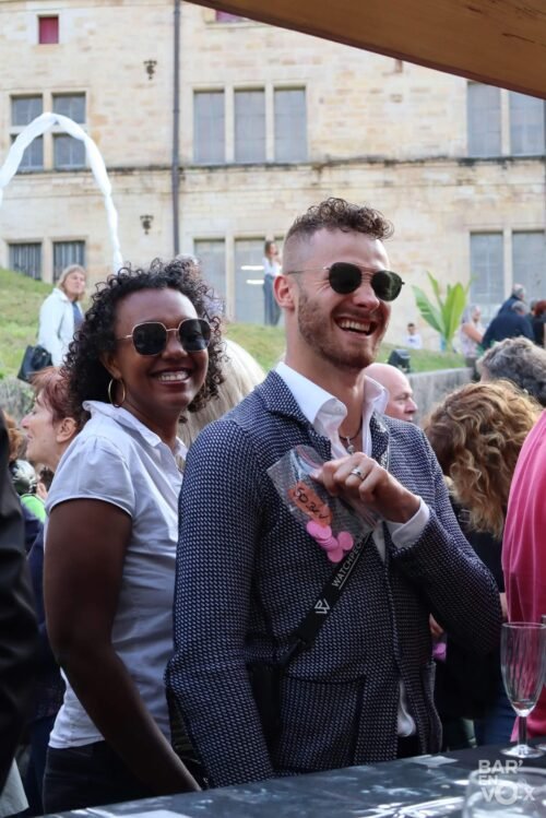 Un homme, avec des lunettes de soleil est fier de présenter ses jetons roses au bar de la guinguette