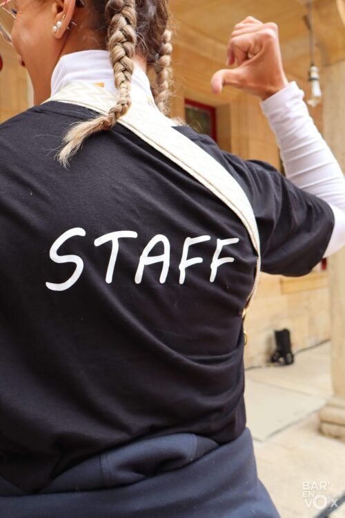 Fati montre le dos de son t-shirt marqé "Staff""