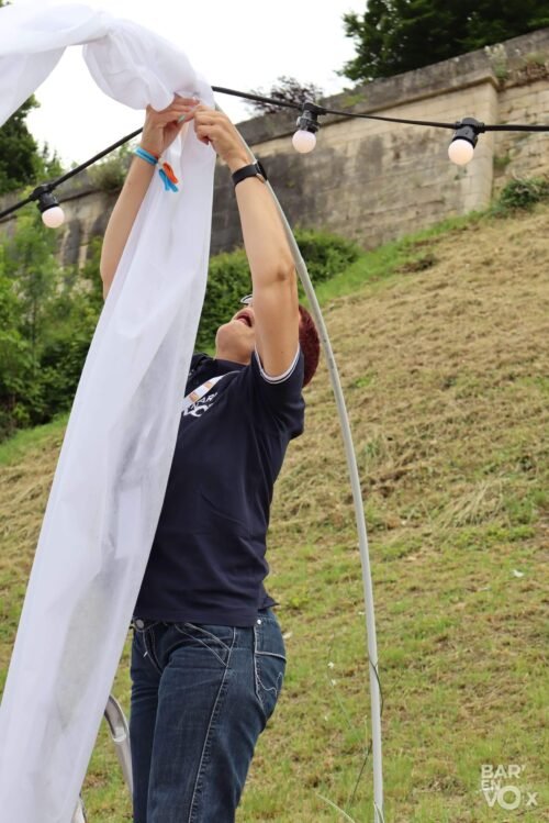 Céline accroche la décoration sur un arceau beaucoup plus grand qu'elle