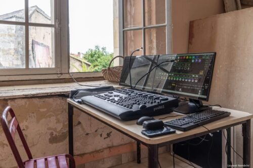 Vue de la console lumière du jardin du collège. Clavier, souris, deux écrans et la console.