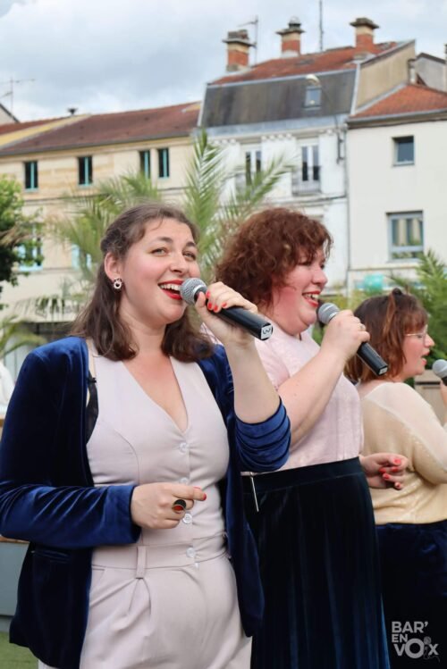 Les Chanteuses Anonymes, chantent sur la place Reggio, micro à la main.