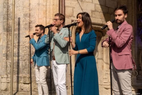 Rebel Bit chante, derrière le micro, sur le parvis de l'église de Longeville-en-Barrois