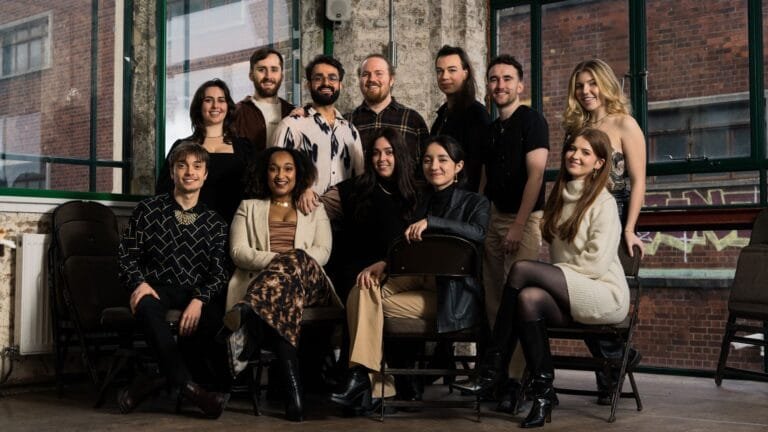 12 chateurs posent devant des fenêtres