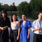Six chanteurs devant un étang boisé