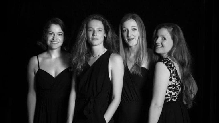Quatre chanteuses en robe posent pour la photo