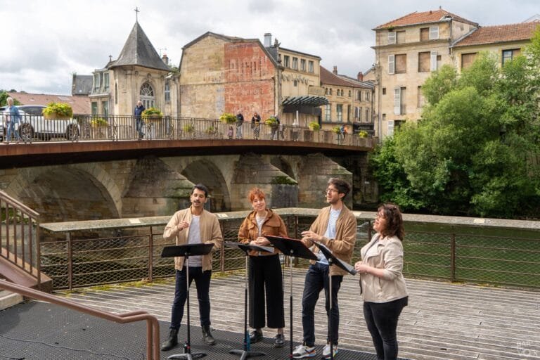 4 chanteurs devant un pont