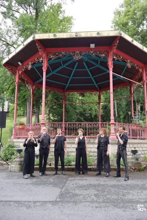 6 chanteurs devant un kiosque à musique