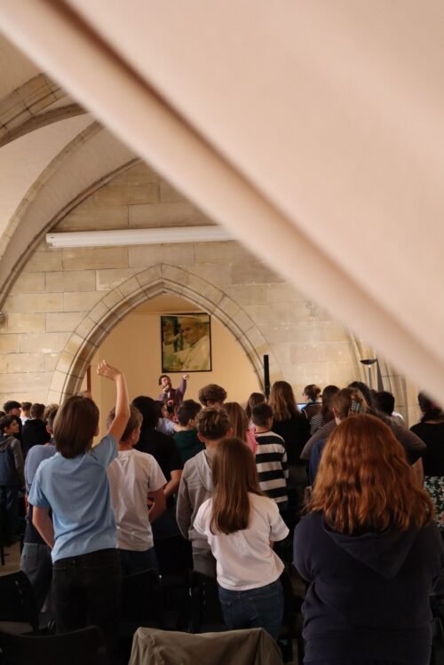 Les élèves vus de dos, le chanteur au fond