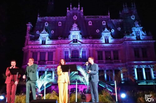 Quatre chanteurs devant un château