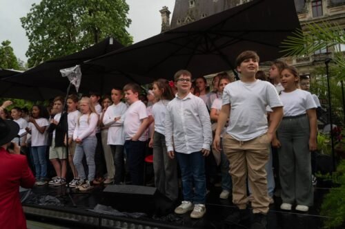 Enfants sur scène sous un parasol contre la pluie